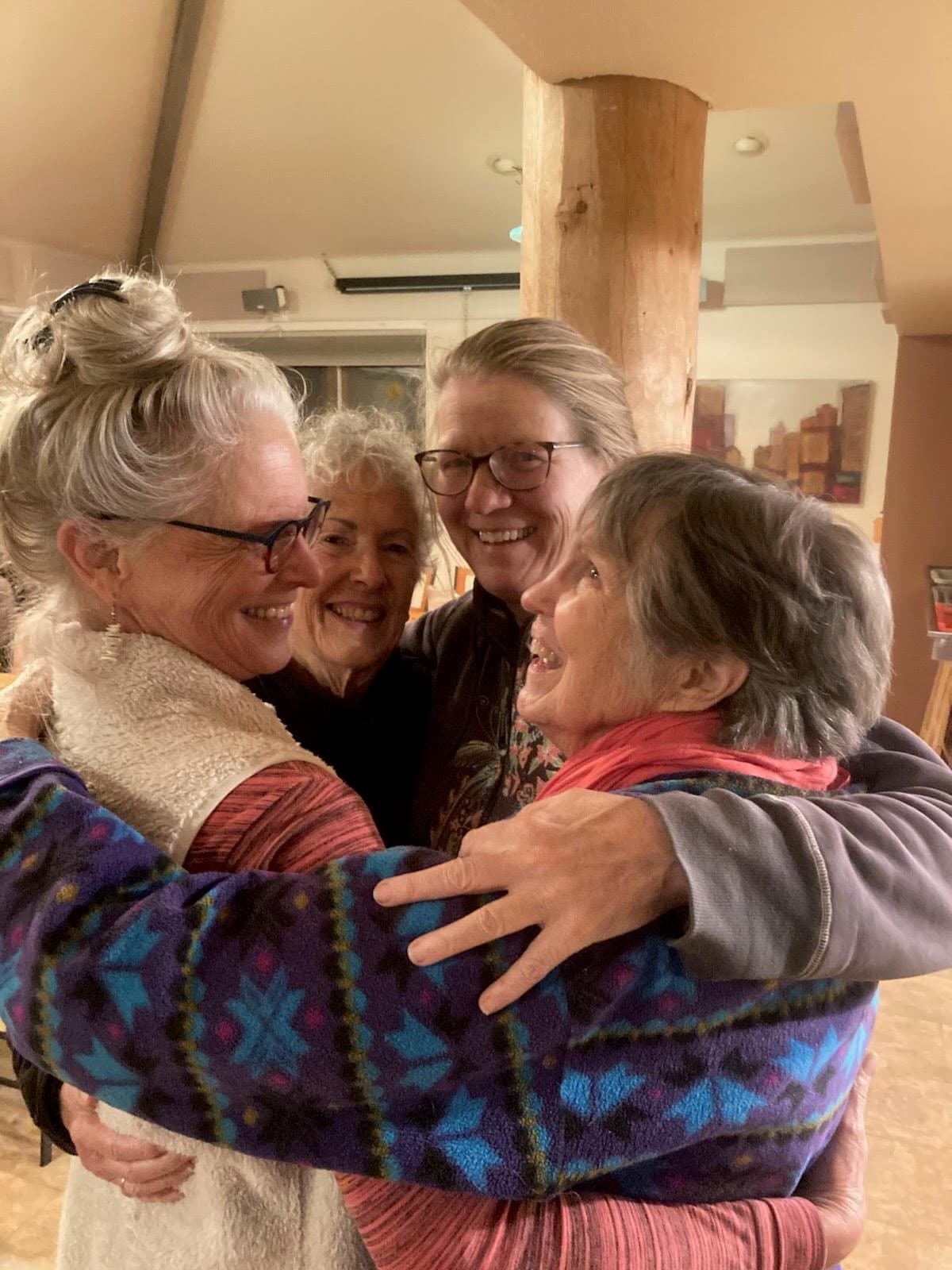 Four Nyland neighbors laughing in a group embrace