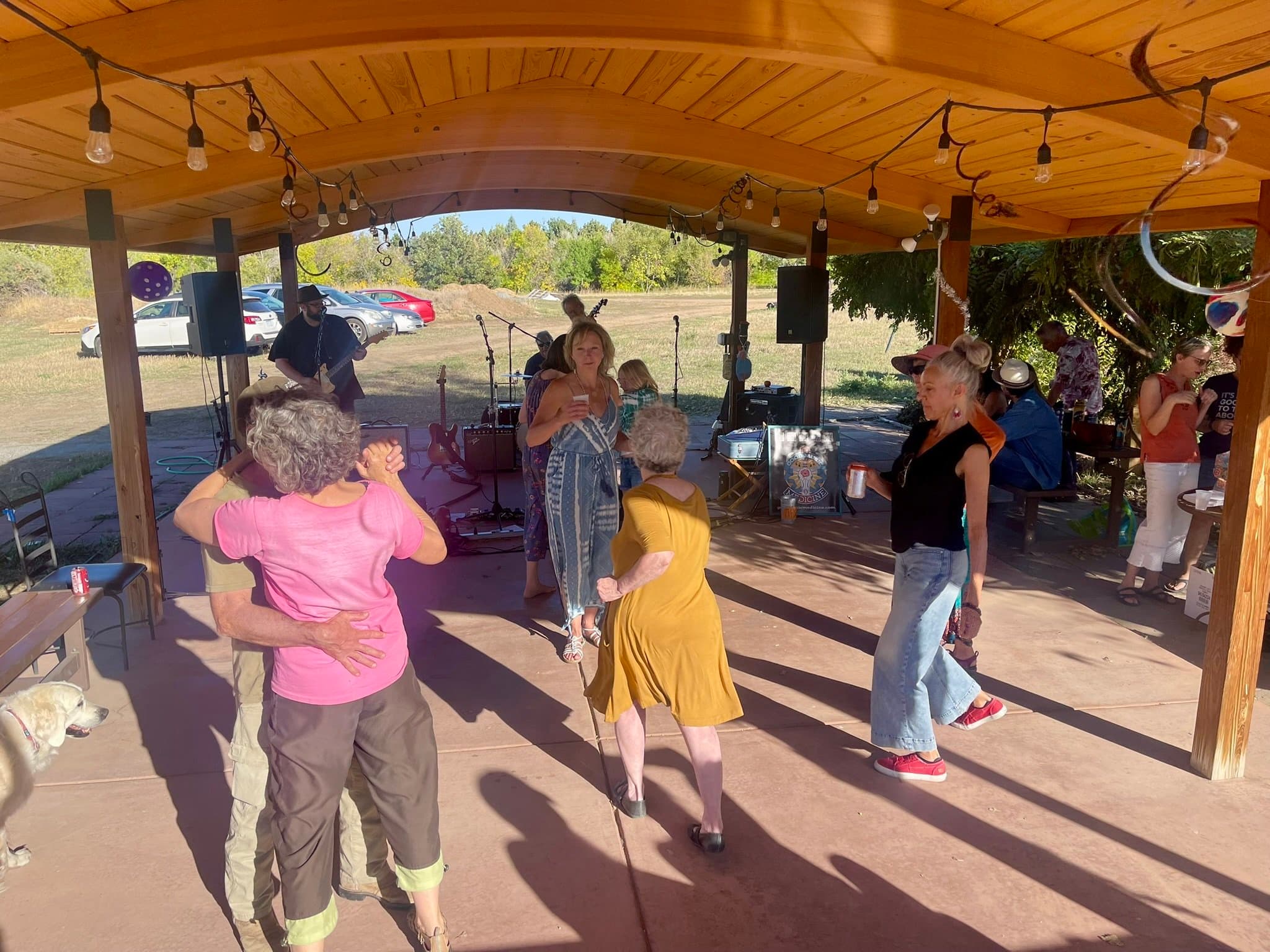 Nyland neighbors dancing under string lights at the pavilion